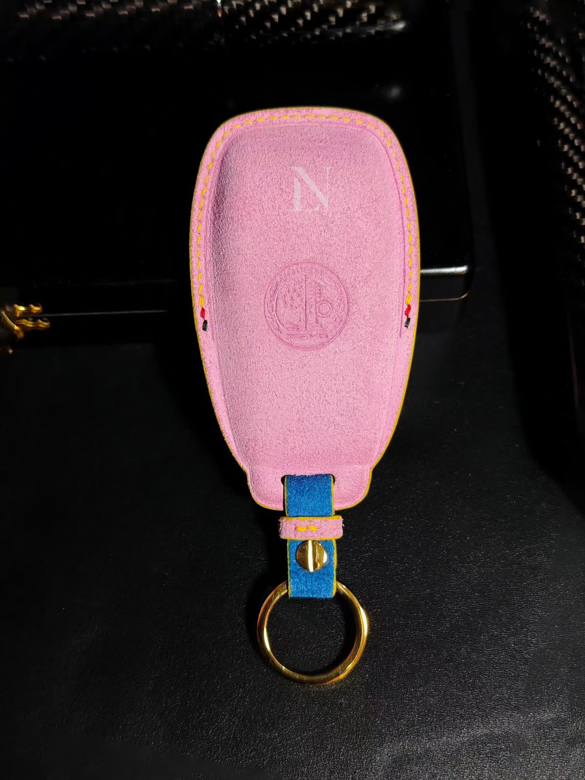 Pink suede Bentley car key case with yellow stitching